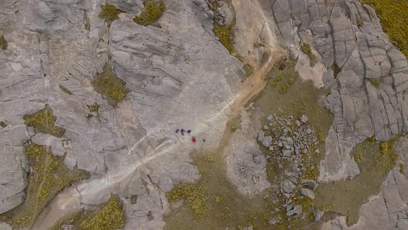 Aerial shot zooming out over hikers, Mount Champaqui, Cordoba Province, Argentina alt