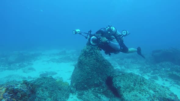 A slow-motion video of a underwater cameraman taking photos in the ocean of marine life with underwa alt