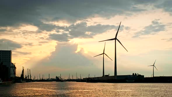 Wind Turbines in Antwerp Port on Sunset. alt