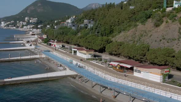 Panorama of the Coastline of Alushta with Clear Black Sea Water and Breakwaters
