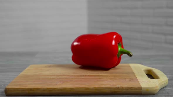 Bell pepper falls on a bamboo cutting board alt