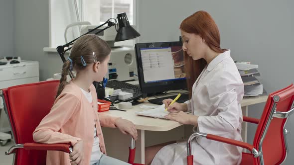 Optometrist Giving Eyeglass Prescription to Child alt