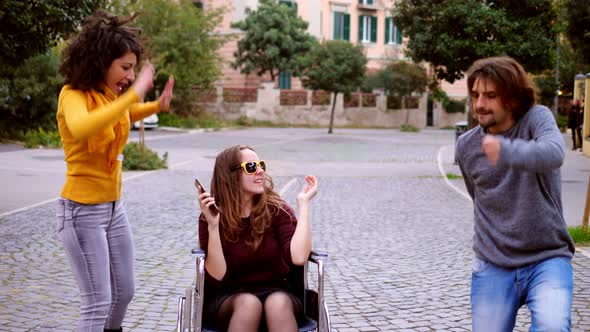 solidarity, affection - young woman using wheelchair dances with his friends alt