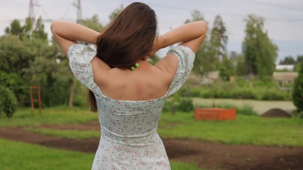 Woman Walking in Garden with Green Plants