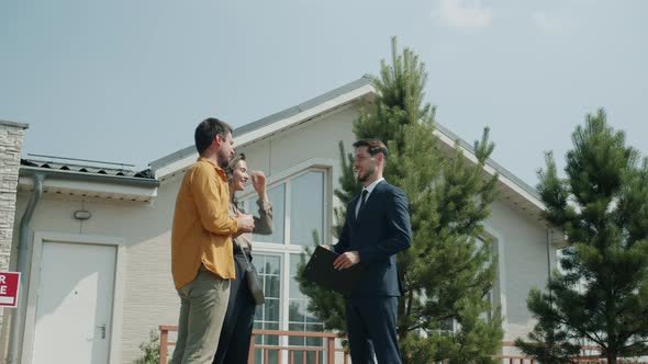 House Buyer Taking Keys From Realtor Shaking Hands Hugging Woman Outdoors alt