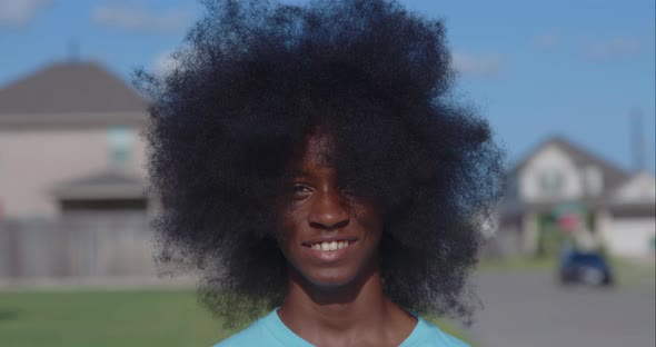 African American adolescent boy with huge Afro looking into the camera alt