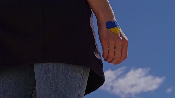 Female Fist Painted in Ukraine Flag Colors with Heart Shape