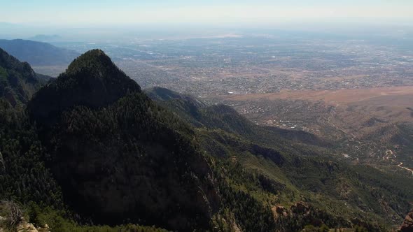 Drone aerial view from the Sandia Mountains of Albuquerque in the distance alt