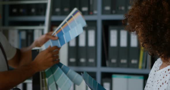 Business Colleagues Discussing Over Color Swatch at Desk 4k alt