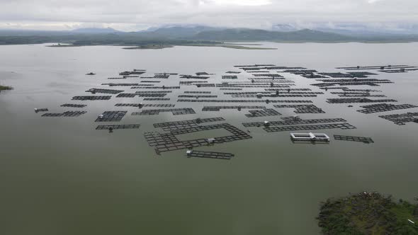 Aerial view of traditional floating fish pond on lake in Indonesia alt