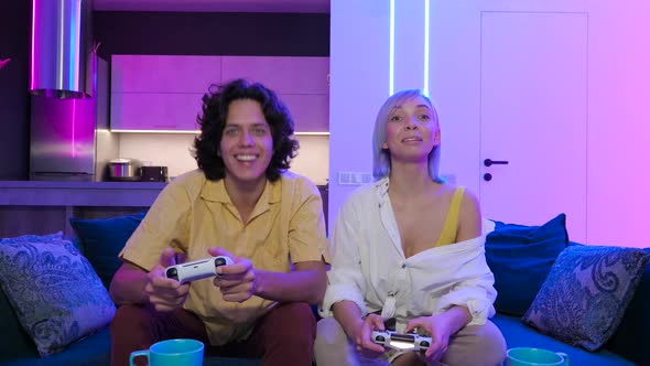 Handsome Young Man Teaching How To Play the Video Games To His Girlfriend, on the Couch, Concept alt