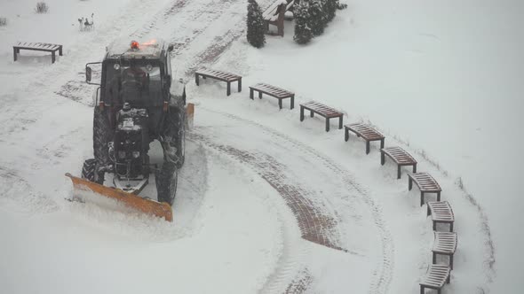 Tractor Vehicle Cleaning the Yard From the Snow Storm alt