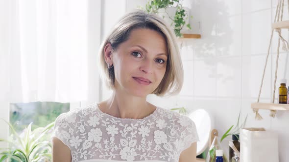 Portrait of Beautiful Middleaged Woman in White Bathroom alt