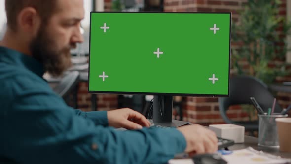 Close Up of Man Working on Horizontal Green Screen at Desk alt