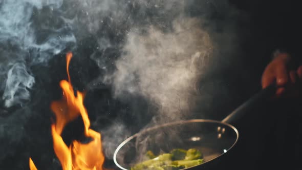 Cook Fries Broccoli in a Pan. Flying Vegetables. Cooking on Fire and Coal. Slow Motion alt