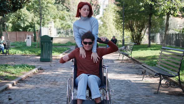 young disabled man listens to music on the phone and dances with his friend alt