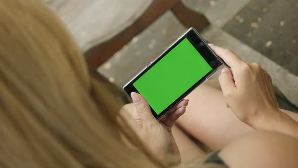 Greenscreen chroma key smart phone  blond woman in the park 4K 2160p 30fps UHD footage - Outdoor blo alt