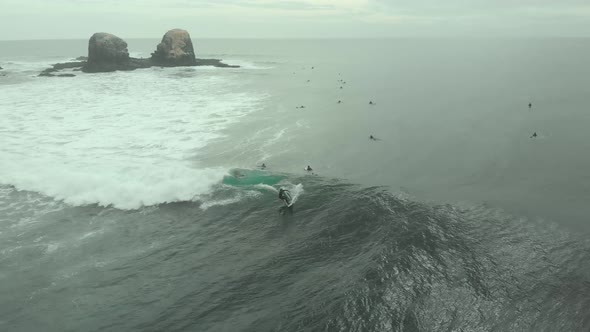 Aerial Shot of Pro Surfer riding  wave and doing tricks on a cloudy day in Pichilemu, Chile-4K alt