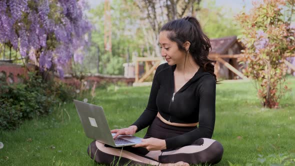 Young Woman Using Laptop in the Garden alt