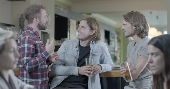 Men drinking beer and talking in pub