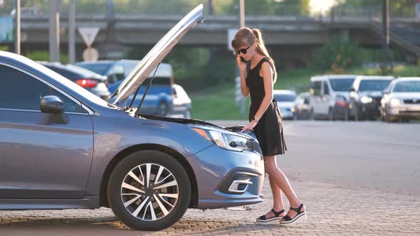 Helpless Woman Standing Near Her Car with Open Hood Takling on Mobile Phone Calling Road Service for alt