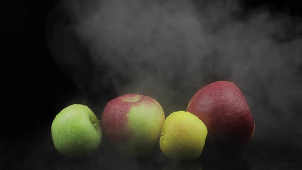 Tropical Fruit Apple in Cold Ice Clouds of Fog Smoke on Black Background alt