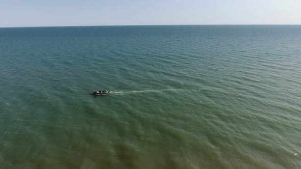 Aerial Shot of a Lonely Boat Floating in the Horizonless Black Sea in Summer