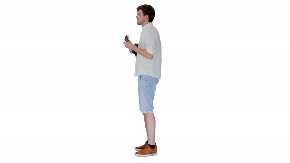 Smiling Young Man Playing Ukulele Looking Into the Camera on White Background alt