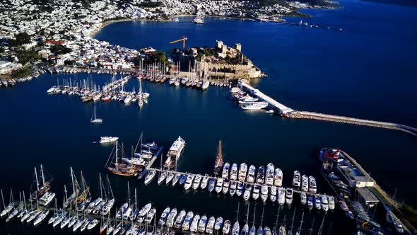 View from drone on full of yachts Bodrum harbour and ancient Kalesi castle in Mugla in Turkey alt