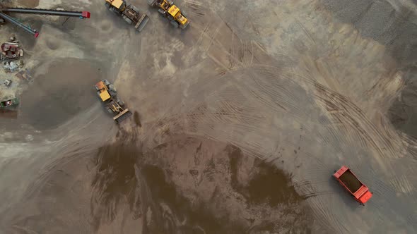 Loaders Tractors and a Dump Truck Drive Off the Gravel Pile at the River Port alt