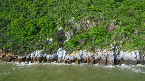 4K aerial view of mountain coast near beautiful beach and sea. Flight over sea. alt