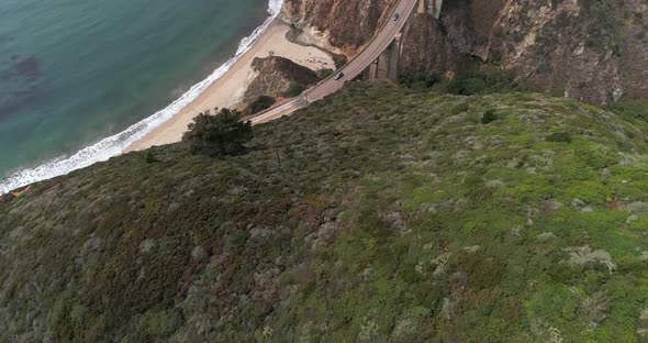 Aerial Drone Stock Video of Bixby Bridge Highway with water and shore below in Big Sur Monterrey Cal alt