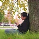 Asian woman typing and slide the screen on smartphone at the park in Autumn - VideoHive Item for Sale