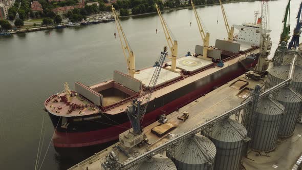 Loading Grain Into Sea Cargo Vessel in Seaport From Silos of Grain Storage alt