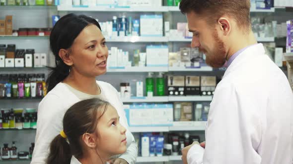 Little Daughter with Her Mom Consult with the a Pharmacist