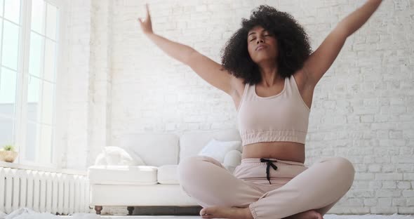 Focused Young Black Woamn Sits Mat Legs Crossed Doing Yoga Breathing Exercise alt