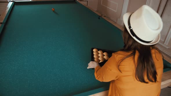 Cinematic Cowboy Woman in a Hat Put Billiard Balls Into A Triangle For A New Game