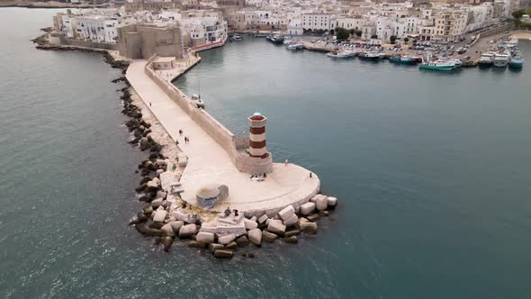 Aerial drone tilt up revealing beautiful Monopoli from a lighthouse. Monopoli, Italy alt