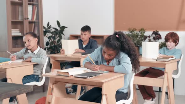 Kids Sitting at Desks in Classroom alt
