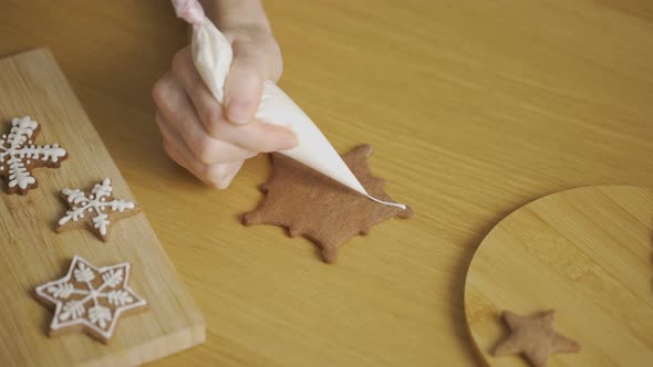 Close-up of a woman decorating a homemade gingerbread Snowflake