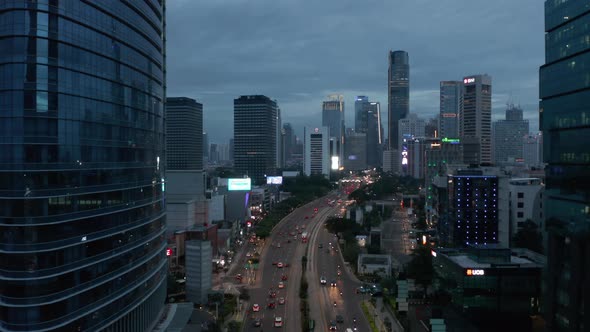 Aerial Pedestal Descending Shot of Night Traffic on a Multi Lane Road Through Jakarta City Center alt