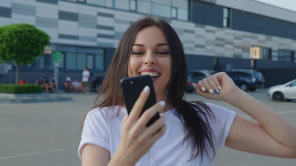 Portrait Trendy Millennial Young Woman Uses a Smartphone on a Urban Background