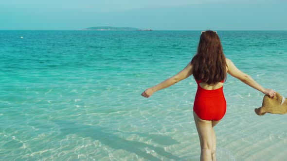 happy woman walking on the sea beach at Koh MunNork Island, Rayong, Thailand alt