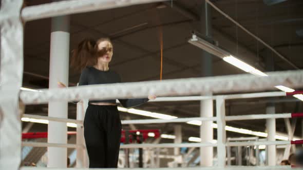 Young Attractive Woman in Sport Clothes Jumping Over the Rope on Boxing Ring alt