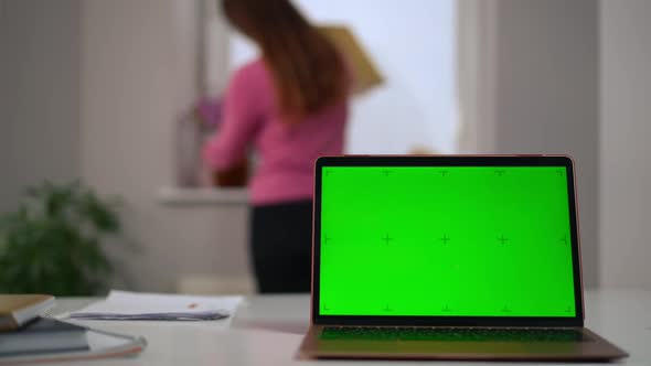 Closeup Green Screen of Laptop with Blurred Woman Walking at Background Checking Flowers Strolling alt