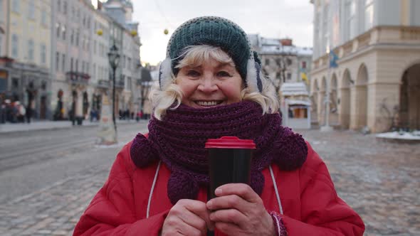 Portrait of Senior Woman Tourist Smiling Looking at Camera in Winter City Center of Lviv Ukraine alt