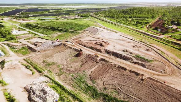 Drone flying towards landfill site as camera slowly tilts down. Location Townsville, Australia. alt