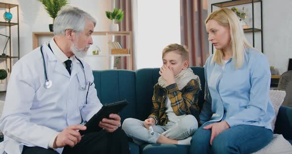 Woman Sitting Near Her Sick Tired Son which Talking with Respected Attantive Doctor alt