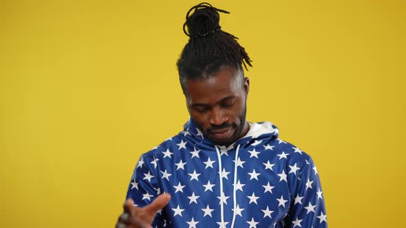 African American Man Making Loser Sign at Forehead with Hand Shaking Head No Looking at Camera alt