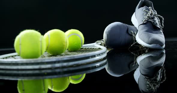 Tennis balls, racket and sports shoe in studio 4k alt